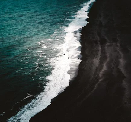 Le contraste saisissant de l'océan Atlantique et du sable noir de Reynisfjara
