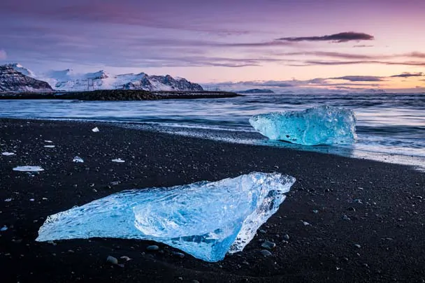 Deux icebergs sur la plage de diamants sous le ciel rosé