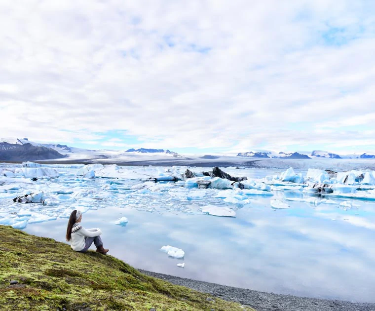 Une touriste admirant les paysages du lagon glaciaire de Jokulsarlon